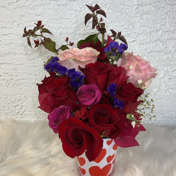 Bouquet of red and pink roses in a heart-patterned cup