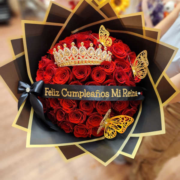 Red rose bouquet with a jeweled crown and black-and-gold wrapping