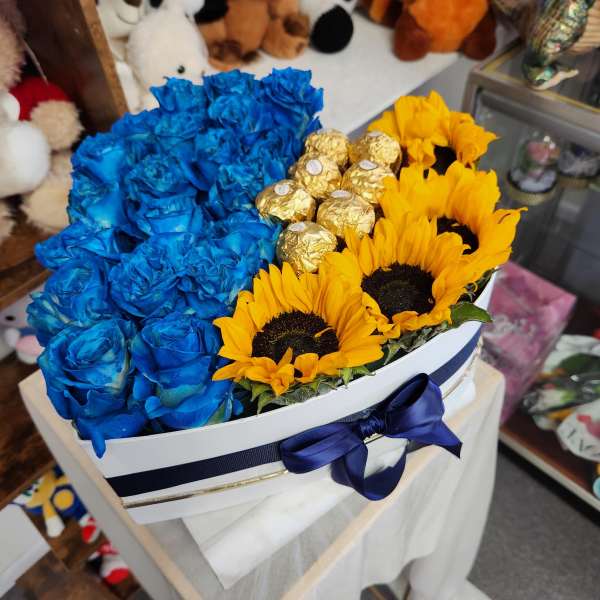 Blue roses and yellow sunflowers in a white hat box with gold chocolates