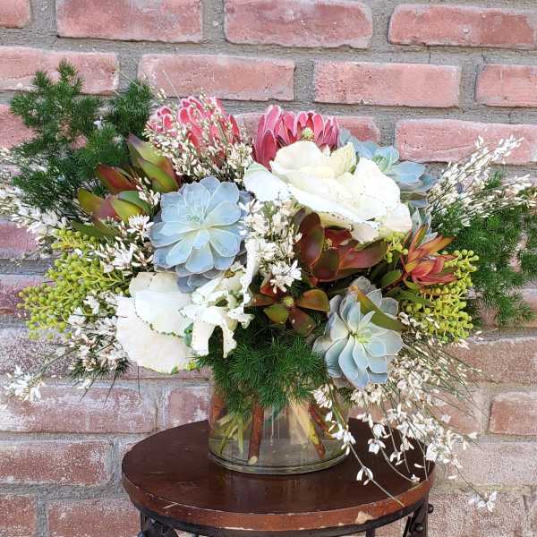 Mixed bouquet with succulents and white flowers in a glass vase