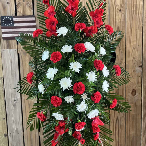 Standing floral spray with red and white flowers on a wire easel