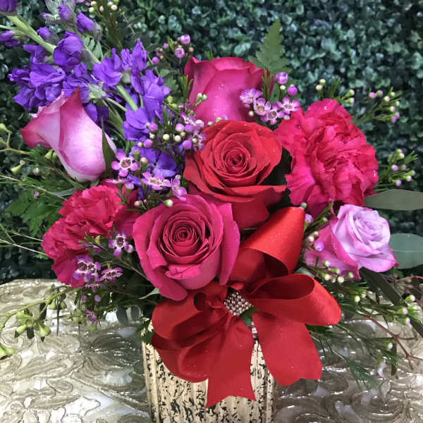 Pink and red rose bouquet with purple flowers in a square vase