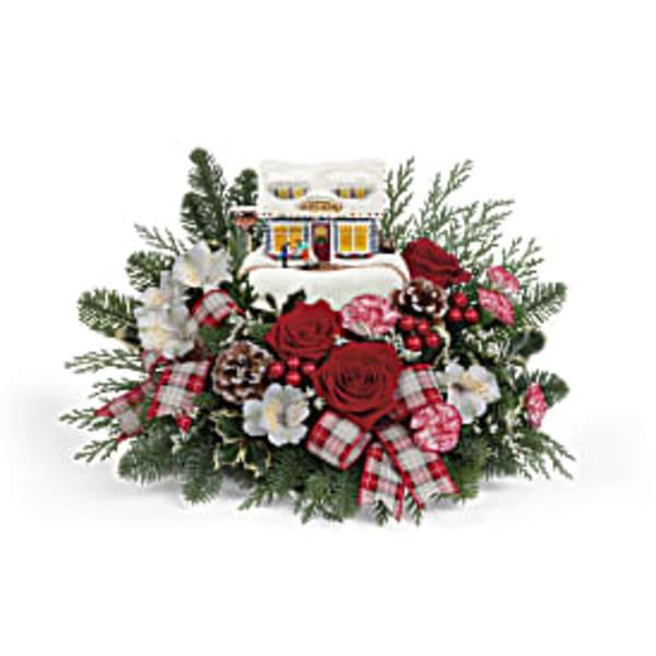 Christmas floral arrangement with red roses and a small house ornament