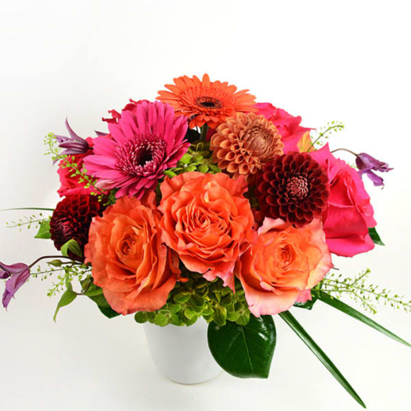 Bouquet of orange and pink flowers in a white vase