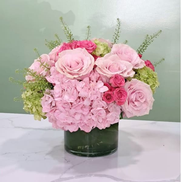 Pink roses and hydrangeas arranged in a glass vase