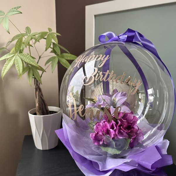 Purple birthday balloon with flowers and ribbon