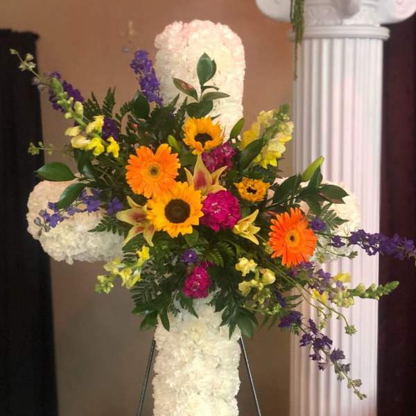 Standing floral cross with white flowers and bright mixed blooms