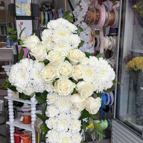White rose and chrysanthemum cross arrangement on an easel