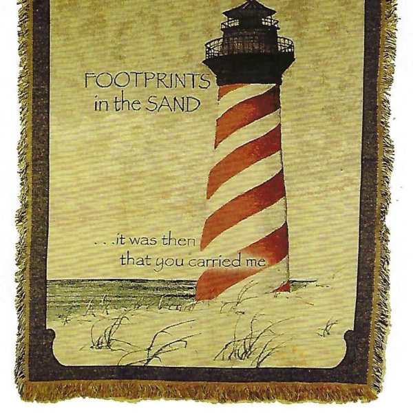Decorative blanket with a lighthouse and the words "Footprints in the Sand"