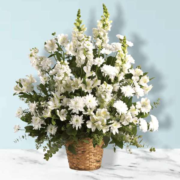 White mixed flower arrangement in a woven basket