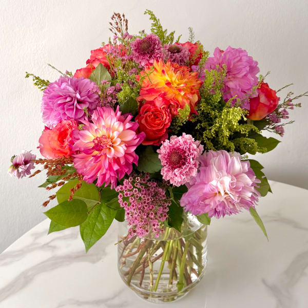 Bright pink and orange mixed bouquet in a clear glass vase