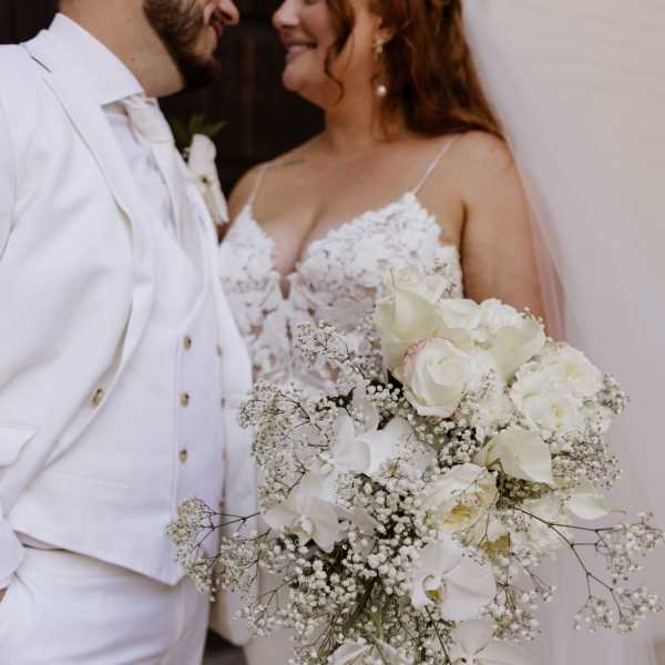Bride and groom holding a cascading white wedding bouquet