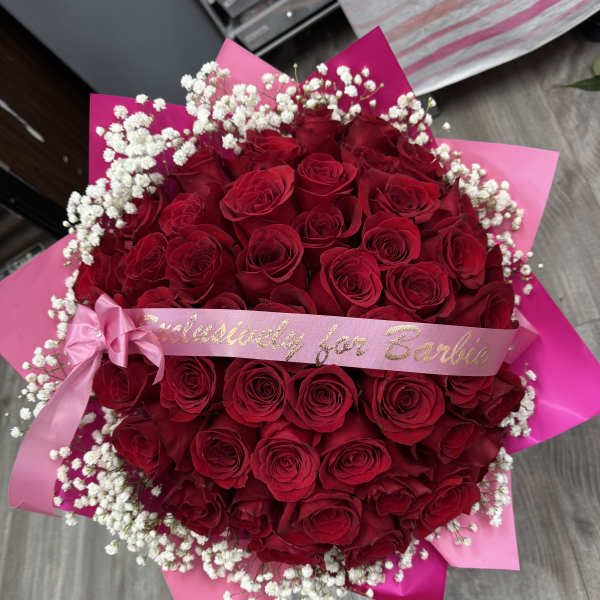 Large bouquet of red roses with white baby's breath and pink ribbon