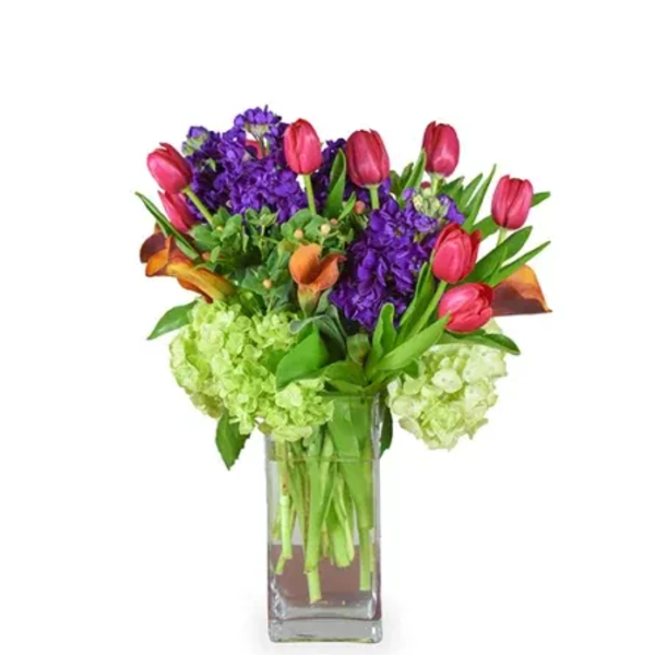 Bouquet of pink tulips and purple flowers in a glass vase