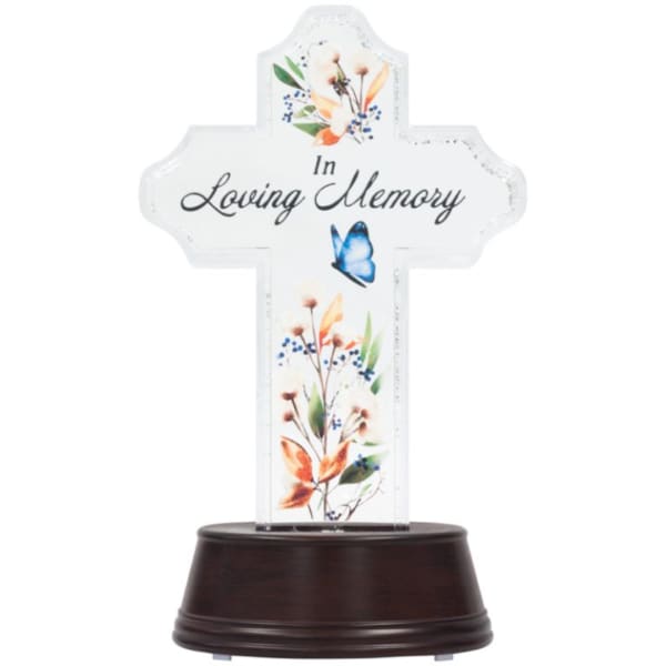 Cross-shaped memorial plaque with floral accents on a dark base