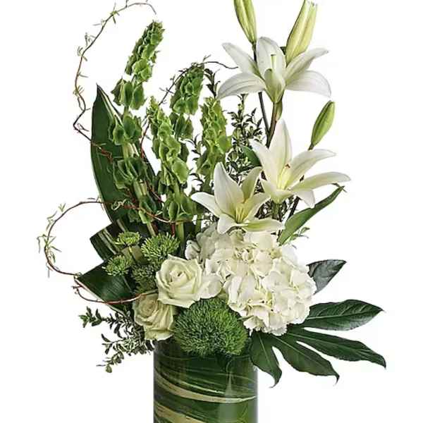 White lilies and hydrangeas in a green glass vase