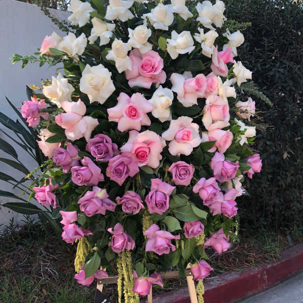 Large standing arrangement of pink, lavender, and white roses