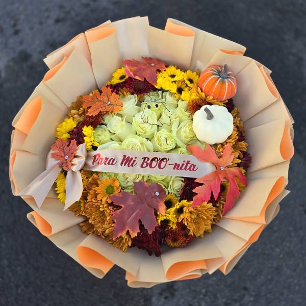 Fall bouquet of yellow and orange flowers with pumpkin decorations