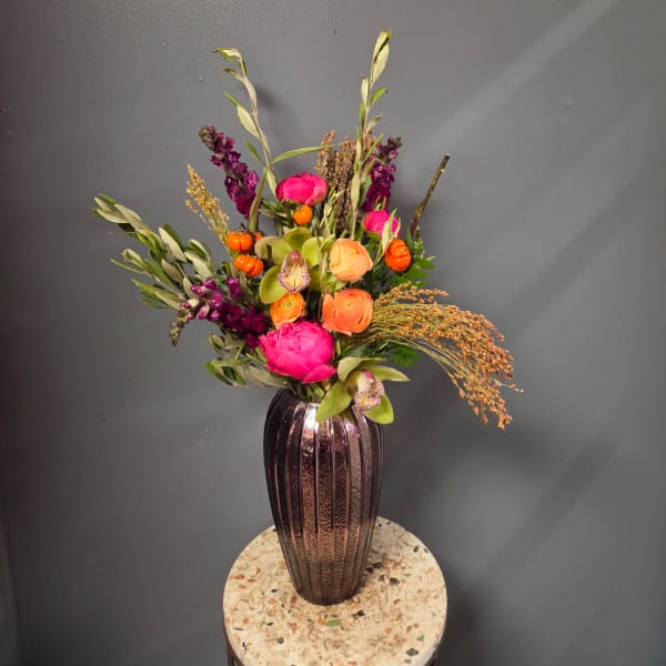 Colorful mixed flower arrangement in a tall ribbed vase