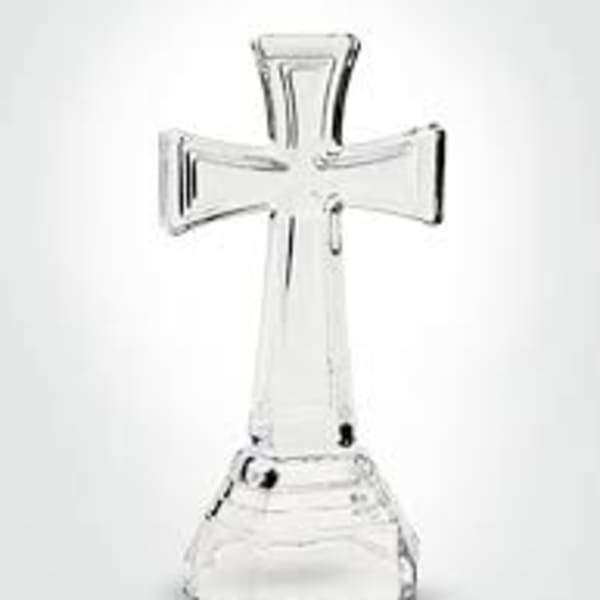 Clear glass cross-shaped candle holder on a white background