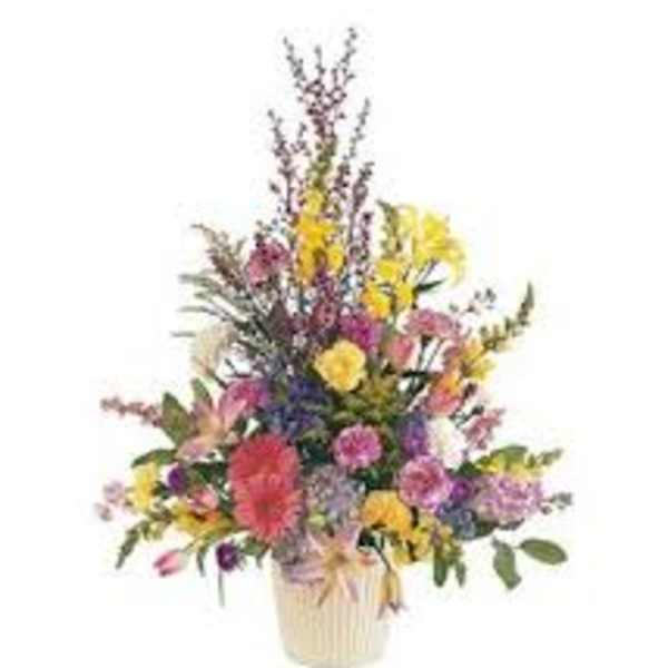 Mixed bouquet of colorful flowers in a cream vase