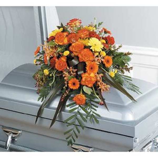 Orange and yellow floral spray on a silver casket