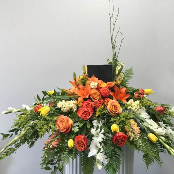 Large orange and yellow floral spray with roses and lilies