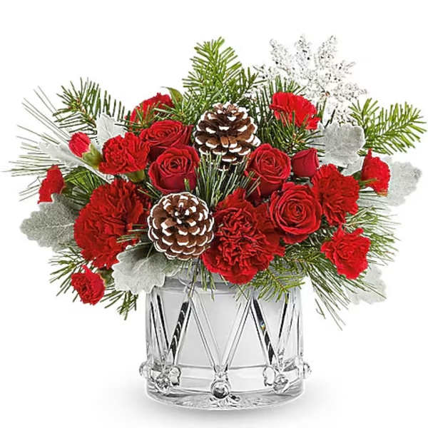 Red roses and carnations in a clear glass vase with pinecones and evergreen accents
