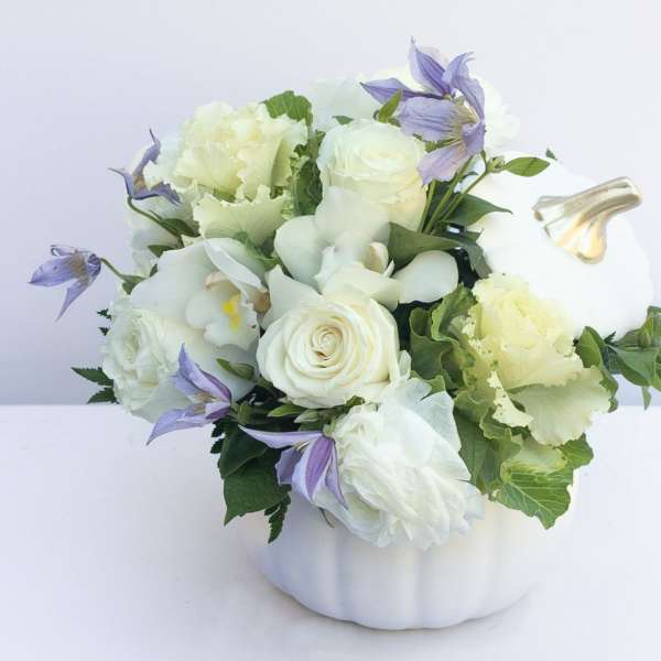 White and lavender floral arrangement in a white pumpkin-shaped container