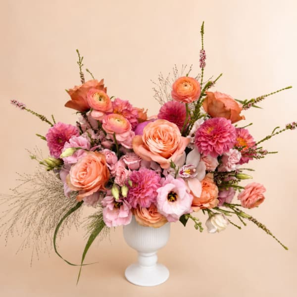 Peach and pink mixed bouquet in a white pedestal vase