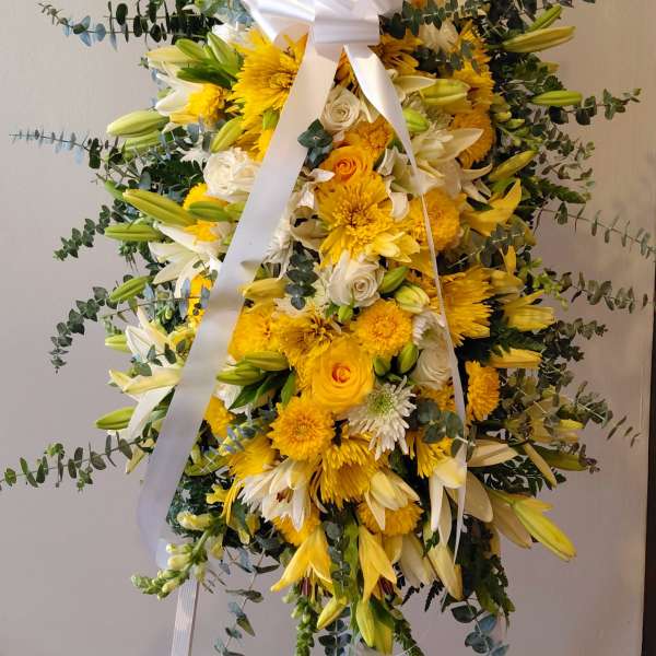 Empathy arrangement of lilies, chrysanthemums, roses, and yellow dragon tree leather. A lovely arrangement to show empathy.