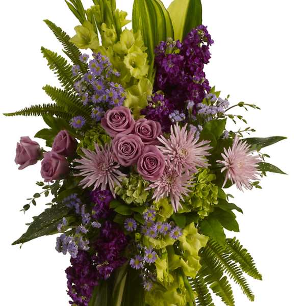 Tall floral standing spray with purple, pink, and green flowers on a white easel