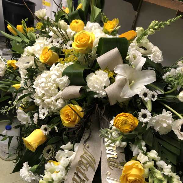 Large white and yellow funeral wreath with ribbon