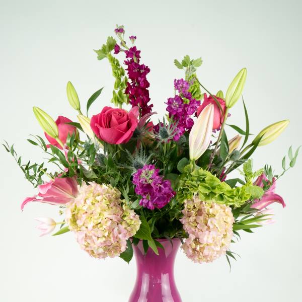 Pink and purple mixed bouquet in a magenta vase