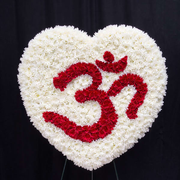 Heart-shaped floral tribute of white and red flowers on a stand