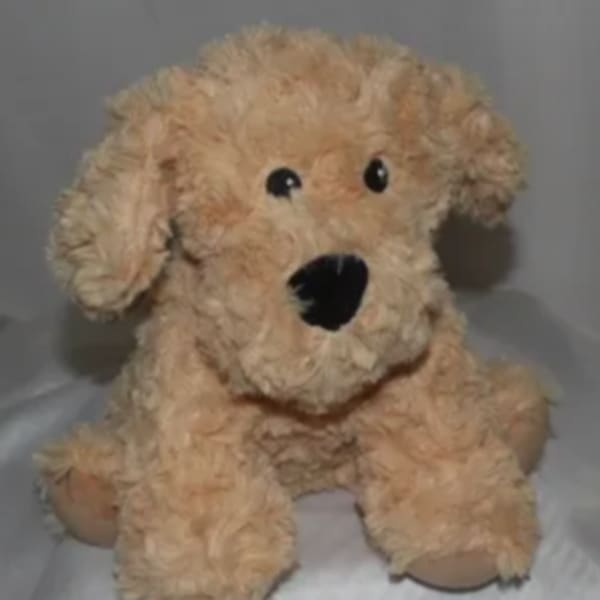 A beige plush dog toy with floppy ears and black eyes.