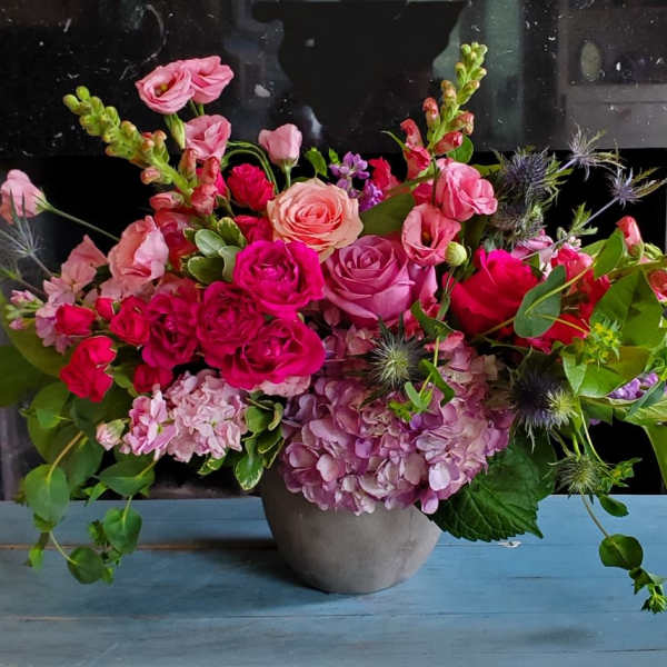 Mixed pink floral arrangement in a gray vase