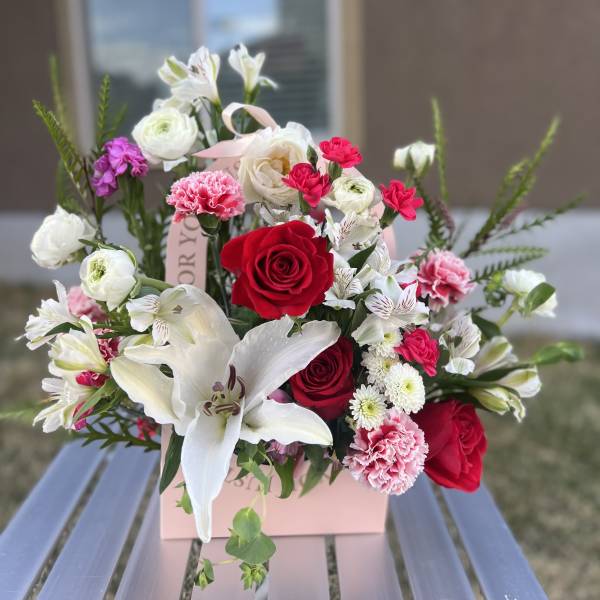 Bouquet of red and white flowers in a pink gift box