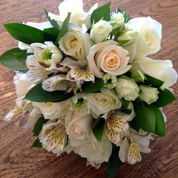 Bouquet of white roses and white alstroemeria with green leaves
