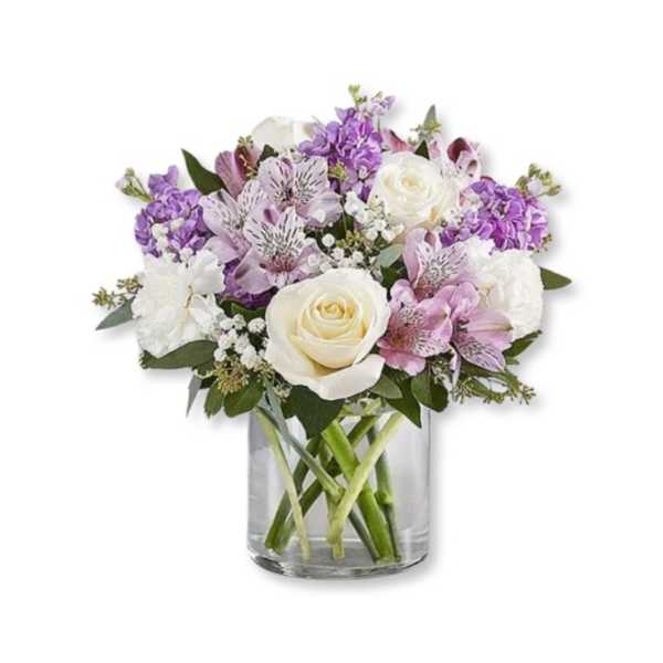 Bouquet of white and purple flowers in a clear glass vase