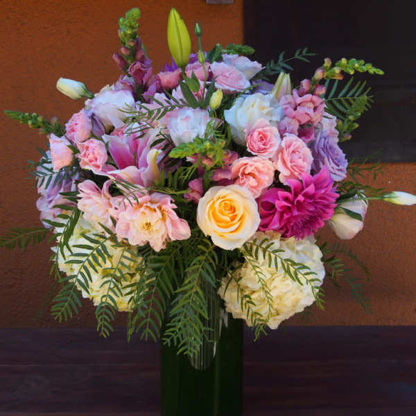 Mixed pink and white flower bouquet in a tall glass vase