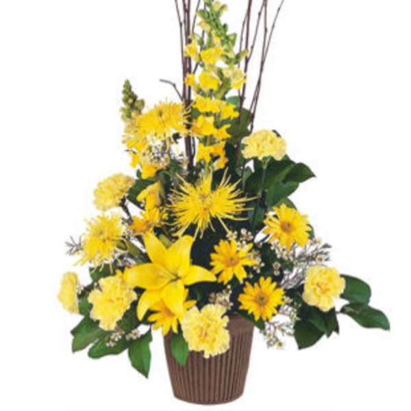 Yellow floral arrangement in a brown vase with tall branches
