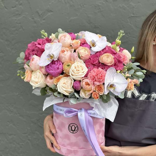 Pink and peach bouquet in a round box with white orchids