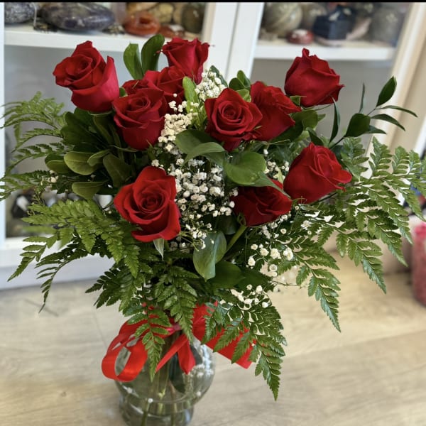 Bouquet of red roses with baby's breath in a glass vase