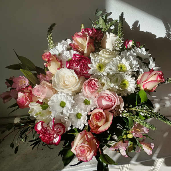 Bouquet of pink and white roses with white daisies and greenery