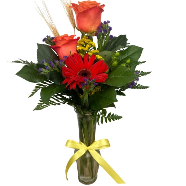 Bouquet of red roses and a red gerbera daisy in a glass vase