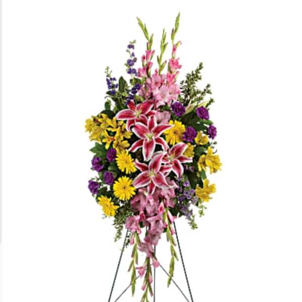 Standing floral spray with pink lilies, yellow daisies, and purple flowers