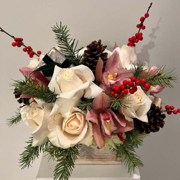 Bouquet of white roses and pink orchids with pinecones and red berries