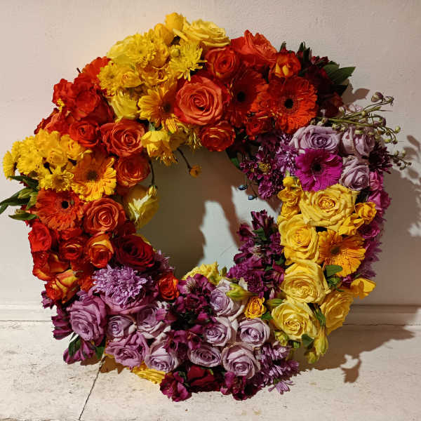 Colorful floral wreath with roses, gerbera daisies, and chrysanthemums