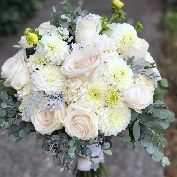 Bouquet of white roses and pale blooms with eucalyptus